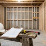 Basement framing inspection with clipboard hard hat and measuring tools
